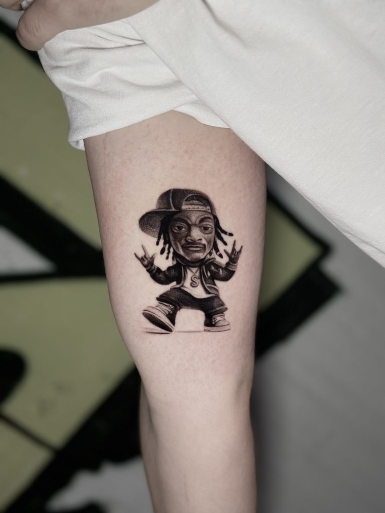 Sude Kara tarafından yapılan şapkalı hip-hop karakteri siyah gri karikatür dövmesi